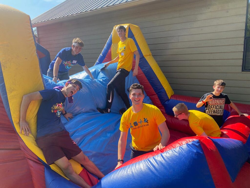 Group of boys playing is a semi deflated bouncy house