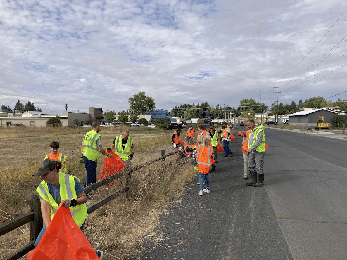 people wearing safety vests working roadside